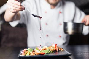Chef che condisce un piatto